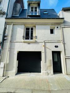 um edifício branco com duas portas de garagem e uma janela em Le Mathilde Cocoon in the heart of Les Halles em Tours
