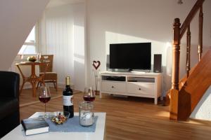 a living room with a television and a table with wine glasses at Ferienwohnung Ostseeglück, Schönberger Strand, Meerblick in Stakendorfer Strand