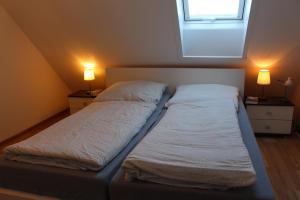 ein großes Bett in einem Zimmer mit zwei Lampen in der Unterkunft Ferienwohnung Ostseeglück, Schönberger Strand, Meerblick in Stakendorfer Strand