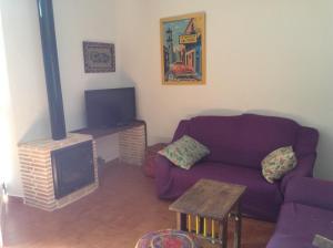 sala de estar con sofá púrpura y chimenea en Cortijo Los Flamencos, en Cabo de Gata