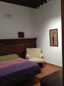 a bedroom with a bed and a chair at Cortijo Los Flamencos in El Cabo de Gata