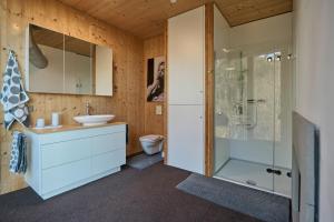 a bathroom with a toilet and a sink and a shower at Design Apartment mit Panoramafenster & Naturblick - KLIMATISIERT in Bregenz +20 photos