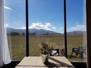 ventana con mesa y vistas a un campo en Ollagua Tiny House Sierra de la Ventana en Tornquist