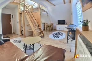 a living room with a spiral staircase in a room at Ski Tour Apartments in Zakopane