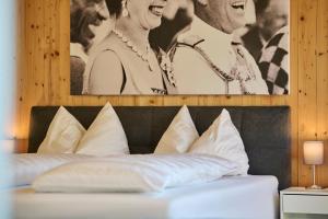 - un lit avec des oreillers blancs et une photo de couple dans l'établissement Design Apartment mit Naturblick, à Bregenz