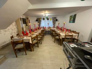 a dining room with tables and chairs with red candles at Casa de vacanța Tara in Rau Sadului