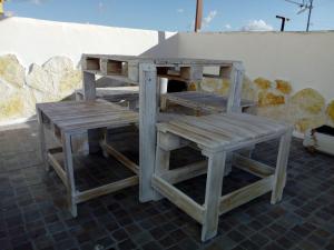 un par de bancos de madera sentados junto a una mesa en Appartamento L'Ammiraglio en Trapani