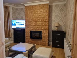 a living room with a fireplace and a television at Cheerful 4-bedroom holiday home close to the Sea in Blackpool