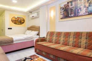um quarto de hotel com um sofá e uma cama em BLUE MARMARA SUITES em Istambul