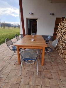 una mesa de madera y sillas en un patio en APARTMA RANČ LUŽE en Kranj