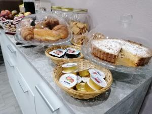 uma mesa com cestas de pão e bolos em Dimora Bed and Breakfast em San Gavino Monreale
