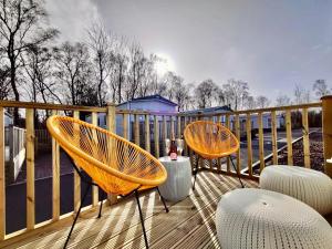 Duas cadeiras e uma mesa num deque em Discover, Relax, Enjoy - All-Round Luxury Lodge em Carlisle