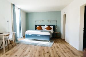 a bedroom with a bed and a table and a desk at Hemma in Aubonne