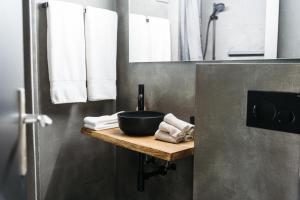 a bathroom with a sink and a bowl on a shelf at Hemma in Aubonne