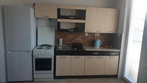 een keuken met een fornuis en een witte koelkast bij Apartman Brezo in Pale