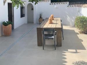 a patio with a wooden table and a chair at Belvilla by OYO Villa Rivas in Jávea
