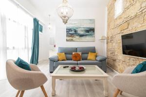 sala de estar con sofá azul y 2 sillas en Allo Apartments Amargura Centro Loft, en Jerez de la Frontera