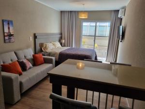 a living room with a couch and a bed in a room at Casa de Playa in Necochea