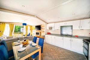 a kitchen and living room with a couch and a table at Discover, Relax, Enjoy - All-Round Luxury Lodge in Carlisle