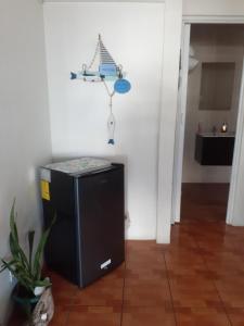 a room with a small black refrigerator in the corner of a room at Atardecer porteño in Puntarenas +10 photos