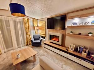 uma sala de estar com um sofá e uma lareira em Discover, Relax, Enjoy - All-Round Luxury Lodge em Carlisle