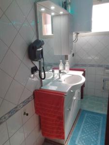 een badkamer met een wastafel en een telefoon aan de muur bij Blu Marlin - IUN Q4073 in Girasole