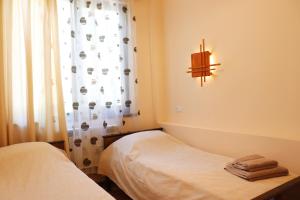 Habitación con 2 camas y ventana con cortina en TOON 94, en Dilijan