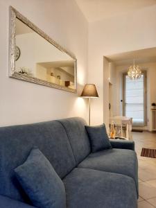 Sofá azul en la sala de estar con espejo en La Perla sul Lago di Como con parcheggio, en Como
