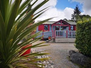 a red and white house with a palm plant at la dune blanche in Camiers