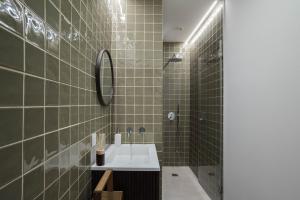 La salle de bains est pourvue d'un lavabo et d'une douche. dans l'établissement Inesquecível estadia na praia de Carcavelos, à Carcavelos