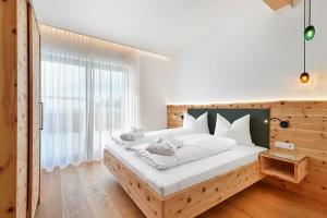 Schmuckstück Ferienapartments Bodenmais في بودنمايس: غرفة نوم بسرير كبير مع اللوح الخشبي
