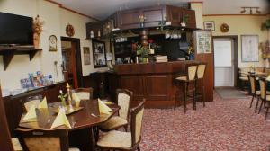 ein Restaurant mit einem Tisch und Stühlen sowie einer Bar in der Unterkunft Gasthaus & Hotel Lindenkrug in Poseritz