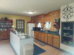 eine Küche mit Holzschränken und einem weißen Kühlschrank in der Unterkunft Hill House Cottage in Hampton