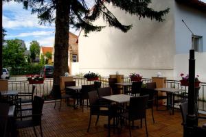 een patio met tafels en stoelen en een boom bij Cáfe 168 in Wenen