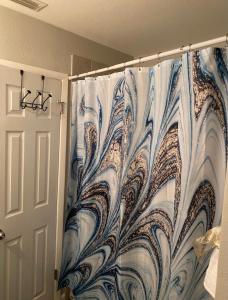 cortina de ducha azul y blanco en el baño en Sweet dreams private room across from the Hard Rock Casino en Tampa