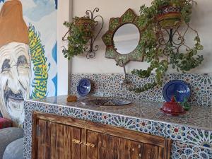 ein Badezimmer mit einer Theke mit einem Spiegel und einer Arbeitsplatte in der Unterkunft Happy Surf Hostel in Taghazout