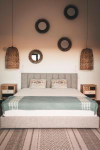 a bedroom with a bed with two mirrors on the wall at Vale Pisco in Bombarral