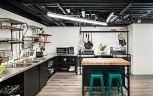a kitchen with black cabinets and green stools at The PAD in Silverthorne