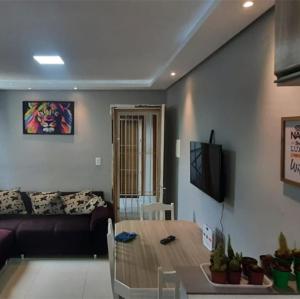 a living room with a couch and a table at Apartamento - Básico Sossego in Porto Alegre