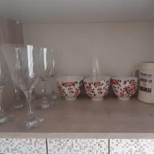 a row of wine glasses sitting on top of a counter at Apartamento - Básico Sossego in Porto Alegre