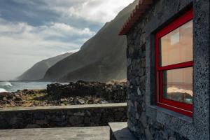 a window of a building with a view of the ocean at Kuanza Nature Experience, Fajã do Belo in Fajã da Caldeira de Santo Cristo