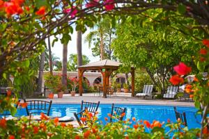 a swimming pool with chairs and a gazebo at Hotel Del Rio in Navojoa