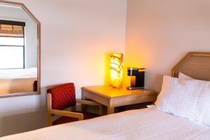 a bedroom with a bed and a desk with a lamp at Two Sunsets Hotel in Panguitch