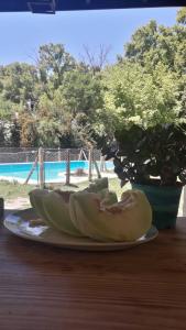 um prato de bananas numa mesa ao lado de uma piscina em COMPLEJO DRUMMOND en el Camino del Vino em Ciudad Lujan de Cuyo