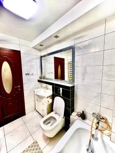 Un baño con inodoro, lavabo y bañera. en Apartament Ultraconfort, en Iaşi