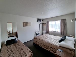 Säng eller sängar i ett rum på ASURE Highpark Motor Inn