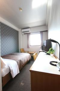 a hotel room with two beds and a desk with a sink at HOTEL LiVEMAX BUDGET Utsunomiya in Utsunomiya