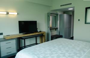 1 dormitorio con 1 cama y escritorio con TV en Holiday Inn Uruapan, an IHG Hotel, en Uruapan del Progreso