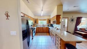 a kitchen with wooden cabinets and a stainless steel refrigerator at Arches East #389 in Moab