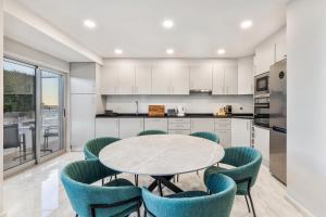 a kitchen with a table and blue chairs at Faro Main Avenue Apartment in Faro